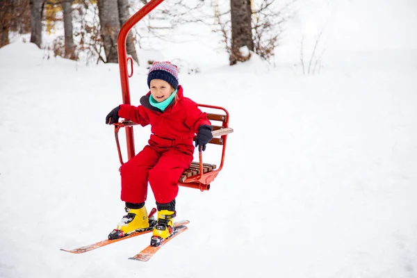 Девочка в красном с креслами на лыжах — стоковое фото