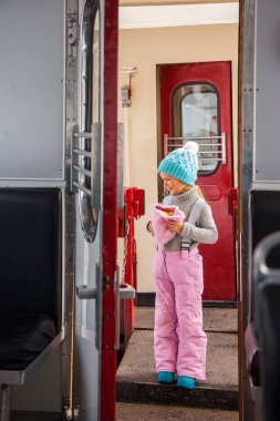 Küçük kız mavi kap ve kış pantolon tarvelling eski tren Kukushka Bakuriani ve Borjomi arasında Gürcistan