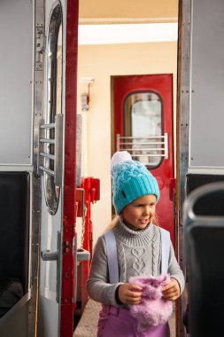 Küçük kız mavi kap ve kış pantolon tarvelling eski tren Kukushka Bakuriani ve Borjomi arasında Gürcistan