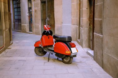 Parlak kırmızı motosiklet döşeli taş dar sokağa park etti.