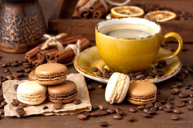 Bir fincan kahve koyu arka plan üzerinde Fransızca macaroons kurabiyeyle. Seçici odak.