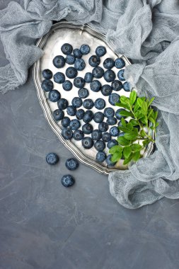 Olgun taze yaban mersini yaprak kase gri taş zemin üzerine, kopya alanı ile üst görünüm ile