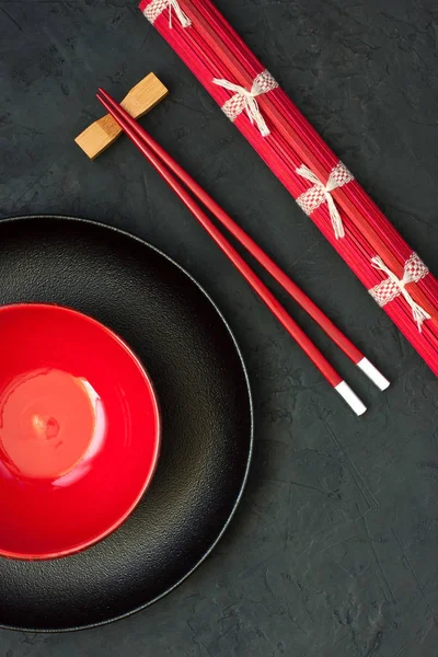 Boş siyah ve kırmızı kase ve beton zemin, üstten görünüm üzerine ahşap çubuk