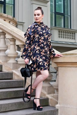 Yazlık elbise genç kadında yürüyerek şehir binalarda merdiven üzerinde