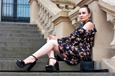 Ateş merdivenlerinde açık havada oturup mutlu rahat kız