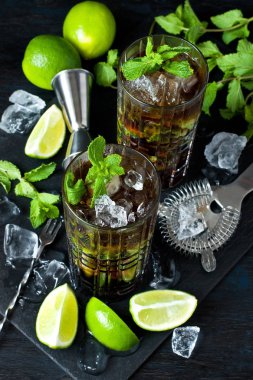 Cuba Libre veya buzlu çay güçlü alkol, cola, kireç ve buz, iki cam, koyu renk arka plan ile kokteyl 