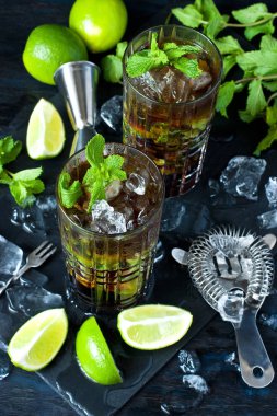Cuba Libre veya buzlu çay güçlü alkol, cola, kireç ve buz, iki cam, koyu renk arka plan ile kokteyl 