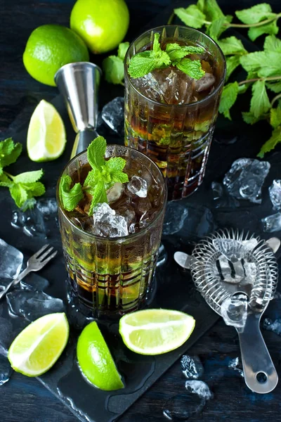 Cuba Libre veya buzlu çay güçlü alkol, cola, kireç ve buz, iki cam, koyu renk arka plan ile kokteyl 