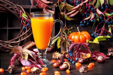 Soğuk içecek mevsimlik sonbahar şükran günü konsepti. Koyu arkaplanda güz süslemeli balkabağı suyu kokteyli.