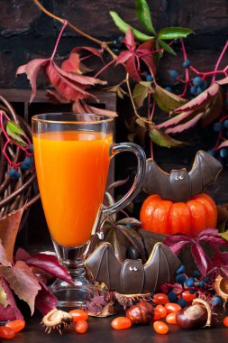 Cadılar Bayramı Balkabağı veya havuç suyu cam koyu arka plan üzerinde