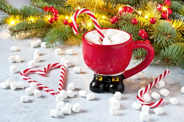 Cup of creamy hot chocolate with melted marshmallows and  candy cane  for christmas holiday