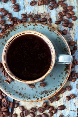 Ahşap arka planda kahve fincanı ve kahve çekirdeği.