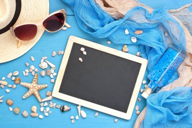 Deniz kabukları ve cam şişe tuz taşlar ve moda aksesuarları üzerinde mavi arka plan ile. Tatil, spa ve rahatlama kavramı