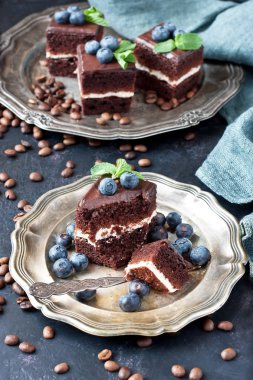  Karanlık beton zemin üzerine bir yaban mersini ve nane ile çikolatalı kek 