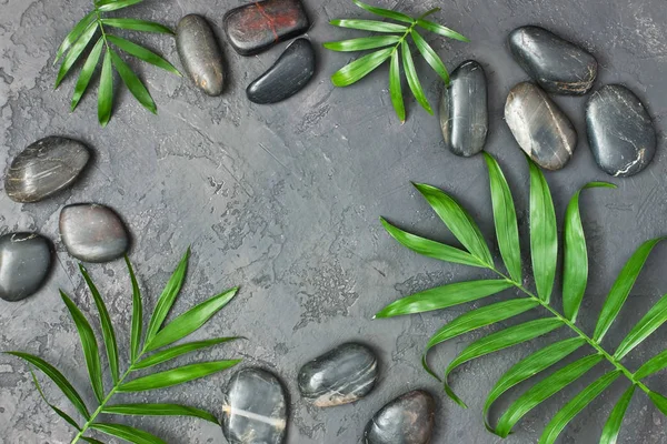 Spa taşlar ve yaprakları gri arka plan üzerinde — Stok fotoğraf