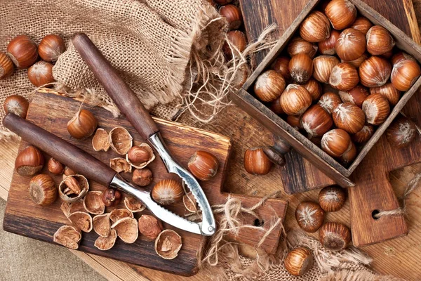 Haselnuss mit Nussknacker auf Holzbrett. Ansicht von oben — Stockfoto