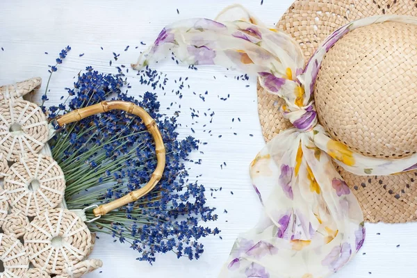 Летняя композиция с плетеной шляпой и лавандовыми цветами на дереве — стоковое фото