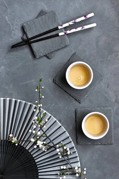 Tea mugs and  cherry  flowers in oriental style, top view — Stock Photo, Image