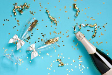 Şampanya şişesi ve renkli arka planda gözlük. Düz yatıyordu 