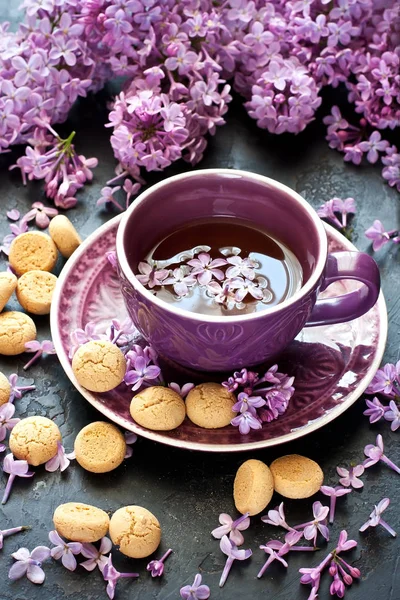 Bodegón con flores lila y té con galletas — Foto de Stock