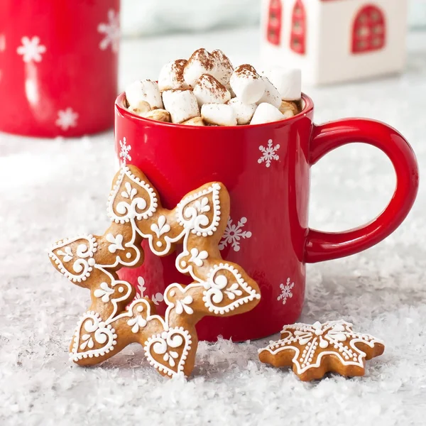 Taza roja llena de chocolate caliente, malvaviscos y galletas de jengibre — Foto de Stock