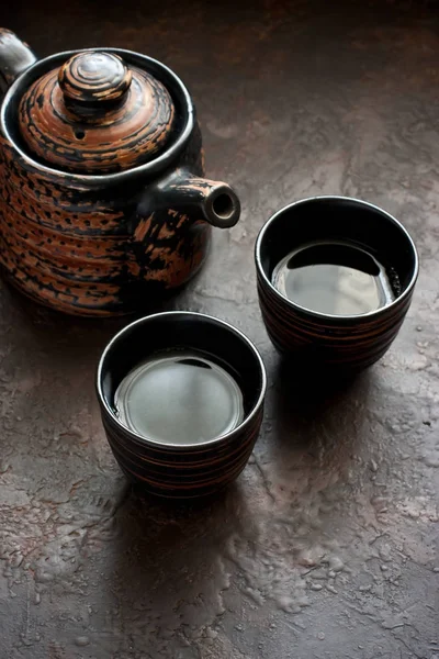 Asian tea bowls and teapot  on  dark stone table — Stock Photo, Image