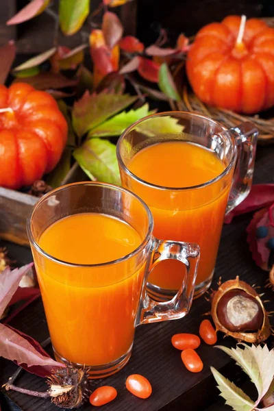 Calabaza de Halloween o jugo de zanahoria en vidrio sobre fondo oscuro —  Fotos de Stock