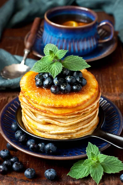 Pfannkuchen mit Blaubeeren auf Keramikteller und Teetasse — Stockfoto