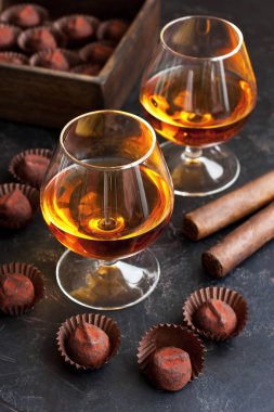 Koyu masa üzerinde brendi veya konyak ve çikolata truffles cam