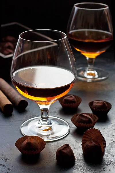 Koyu masa üzerinde brendi veya konyak iki bardak