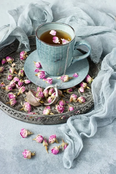 Τσάι με μπουμπούκια τριαντάφυλλο στο δίσκο με ύφασμα υφάσματος. Έννοια της κατανάλωσης τσαγιού — Φωτογραφία Αρχείου