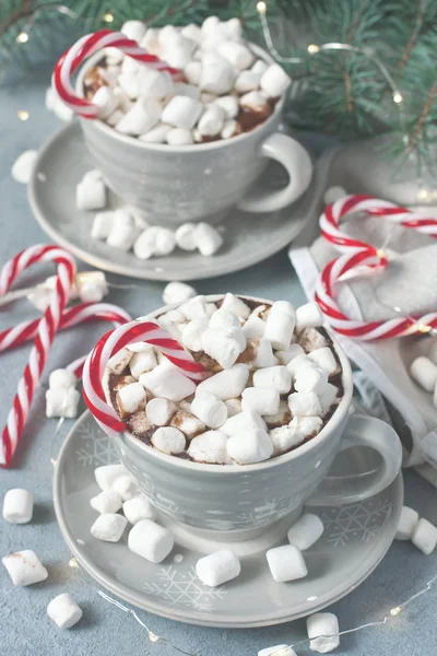 Tazas llenas de chocolate caliente y malvaviscos y bastón de caramelo — Foto de Stock