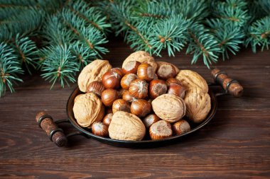Ahşap masada fındık ve ceviz yığını.