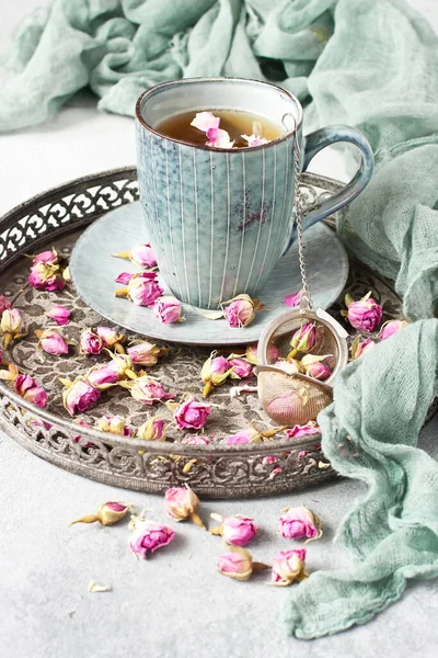 乾燥バラの芽の茶 ティーマグカップとテキスタイル布でトレイ上のヴィンテージふるいと組成物 — ストック写真