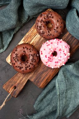 Çikolatalı, pembe jöleli ve vanilyalı çeşitli çörekler.