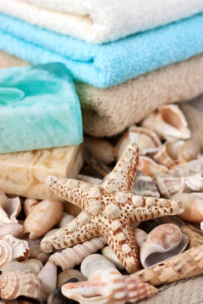 貝殻を背景にしたカラフルな天然のオーガニックソープとタオル リラクゼーションの概念 — ストック写真
