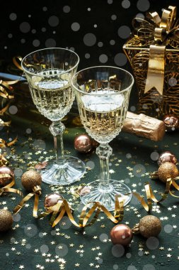 Noel ve Yeni Yıl kutlamaları şampanyayla yapılır. Yeni yıl tatili konsepti. İki şampanya bardağı ve şişe.