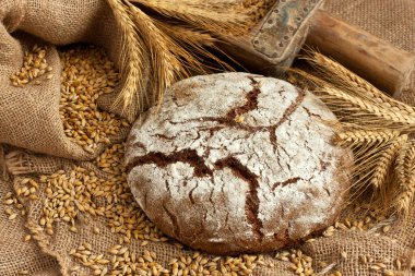 Taze çavdar ekmeği, köy usulü. Çuval bezi arka planında basit bir köy yemeği.
