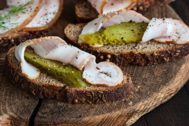 Çavdar ekmeği, domuz pastırması ve tuzlu salatalıkla dolu bir hayat seçici bir odak noktasıyla kapanıyor.