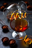 Detailní záběr dvou skleněných pohárů s alkoholem (brandy, koňak, whisky) na tmavém pozadí