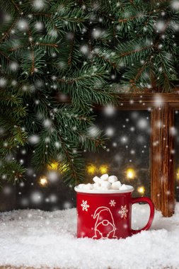 Buzlu pencereli eritilmiş şekerlemeli bir fincan kremalı sıcak çikolata seçici odak ve sığ alan derinliği