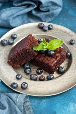 Çikolatalı kek, koyu arkaplanda yaban mersinli tatlı, sığ alan derinliğinde seçici odak