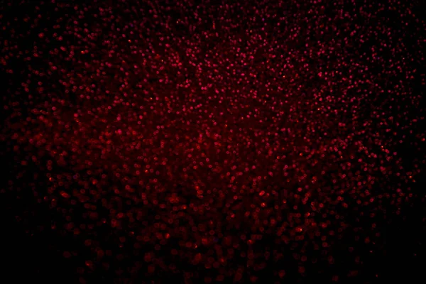 El confeti de purpurina roja abstracta brilla sobre fondo negro . — Foto de Stock