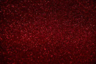 Soyut kırmızı glitter konfeti siyah arka plan üzerinde ışıltılar.