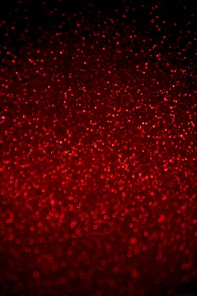 Abstrait rouge paillettes confettis scintille sur fond noir . — Photo