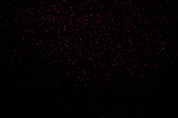 Red and pink falling sparkles on black isolated background. — Stock Photo, Image