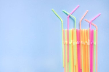 Mavi arka planda renkli plastik pipetler. Kokteyl tüpleri.