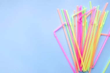 Mavi arka planda renkli plastik pipetler. Kokteyl tüpleri.