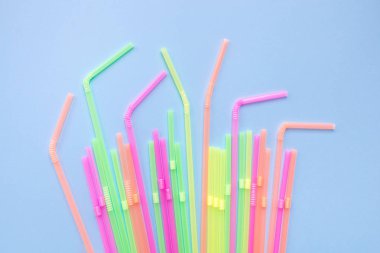 Mavi arka planda renkli plastik pipetler. Kokteyl tüpleri.