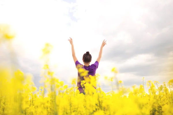 Mujer feliz joven en el campo de canola. Flores de campo amarillo . — Foto de Stock